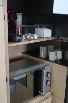 a kitchen with a microwave on a wooden shelf at CAM Maresme 2 Apartamento Barcelona y playa in Masnou