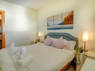 a bedroom with a large white bed with pink pillows at Ocean Skyline Penthouse by Hello Homes Sitges in Sitges