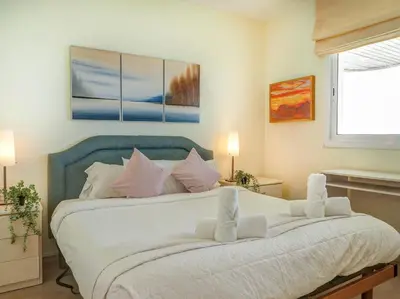 a bedroom with a large white bed with pink pillows at Ocean Skyline Penthouse by Hello Homes Sitges in Sitges
