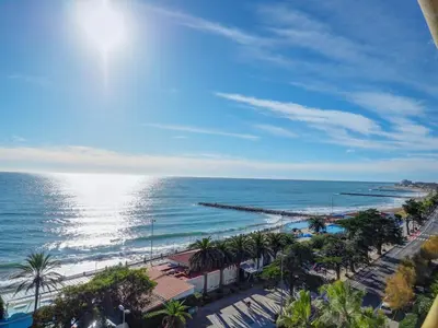 a view of a beach with palm trees and the ocean at Ocean Skyline Penthouse by Hello Homes Sitges in Sitges