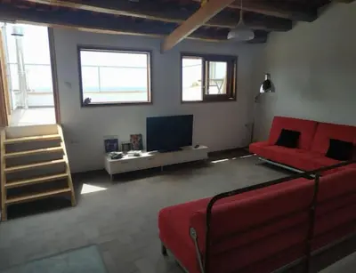 a living room with a red couch and a tv at CAM Maresme 1 apartamento Barcelona y playa in Masnou