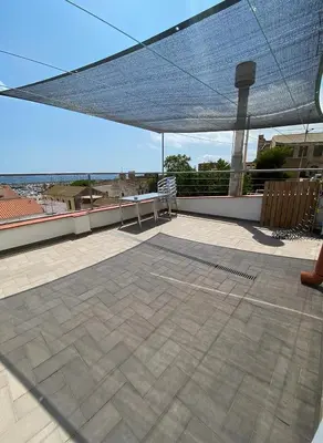 a patio with a table and chairs on a roof at CAM Maresme 1 apartamento Barcelona y playa in Masnou