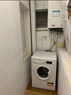 a laundry room with a washing machine and a window at Barcelona estadio nuevo in Hospitalet de Llobregat