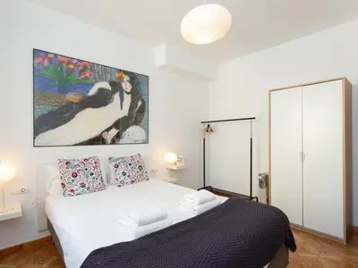 a bedroom with a bed with a painting on the wall at Click&Flat Fira Castelao in Hospitalet de Llobregat
