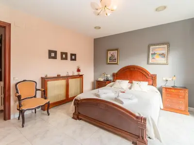 a bedroom with a large bed and a chair at Holiday Home Aurea by Interhome in Pineda de Mar