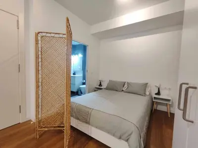 a white bedroom with a bed and a mirror at Mazi Apartments Loft in Mataró