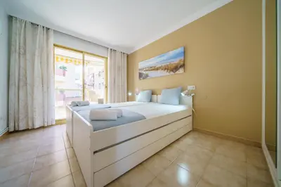 a bedroom with a large bed and a window at HomeHolidaysRentals Liberty - Costa Barcelona in Pineda de Mar