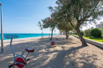 a bike parked on a beach next to the ocean at HomeHolidaysRentals Liberty - Costa Barcelona in Pineda de Mar
