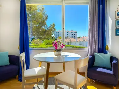 a living room with a table and chairs and a window at The Blue Island Loft by Hello Homes Sitges in Sitges