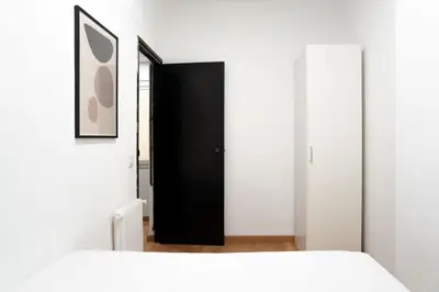a bedroom with a black door and a white bed at The Collection Barcelona - Plaza Urquinaona Central and comfortable 3BD in Barcelona