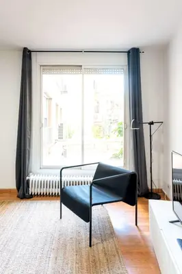 a living room with a chair and a large window at The Collection Barcelona - Plaza Urquinaona Central and comfortable 3BD in Barcelona