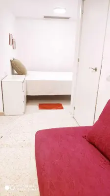 a bedroom with a bed and a red rug at Hostal Estudios in Badalona