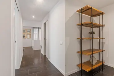 a hallway with wooden shelves and a white wall at CATERINA 22@ POBLENOU in Barcelona