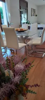 a dining room with a glass table and white chairs at Villa Alba cerca de Sitges in Canyelles