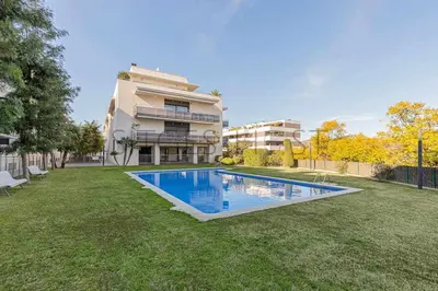 a yard with a swimming pool in front of a building at Sitges PORT - Con piscina, a 5 minutos de la playa in Sitges