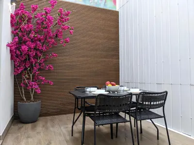 a table and chairs with pink flowers and a tree at WEFLATING Fira in Hospitalet de Llobregat