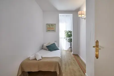 a room with a bed with a blanket and a window at BBarcelona Clot Apartments in Barcelona
