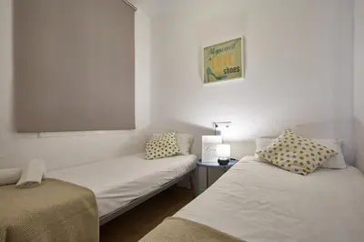 a small room with two beds and a tv at BBarcelona Clot Apartments in Barcelona