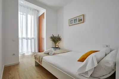 a white bedroom with a large bed in a room at BBarcelona Clot Apartments in Barcelona