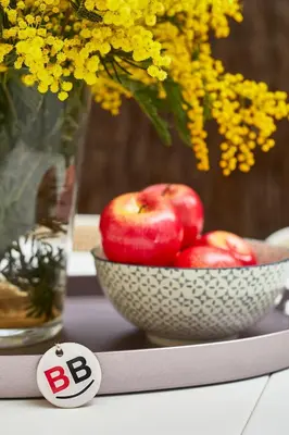 a bowl of apples and a vase with yellow flowers at BBarcelona Clot Apartments in Barcelona