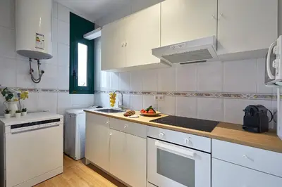 a kitchen with white cabinets and a stove top oven at BBarcelona Clot Apartments in Barcelona