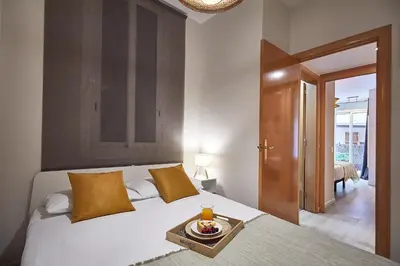 a bedroom with a bed with a tray of food on it at BBarcelona Clot Apartments in Barcelona