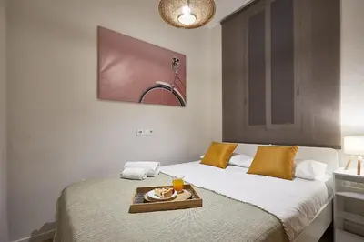 a bedroom with a bed with a tray of food on it at BBarcelona Clot Apartments in Barcelona