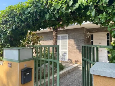 a fence with a trash can in front of a house at Villa Òdena in Odena