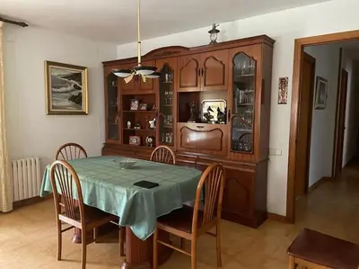 a dining room with a table and chairs and a cabinet at Villa Òdena in Odena