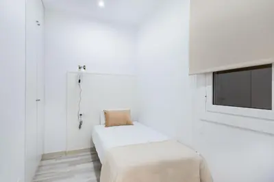 a white bedroom with a bed and a tv at Apartment Next to Sagrada Familia, the Essence of Barcelona in Barcelona