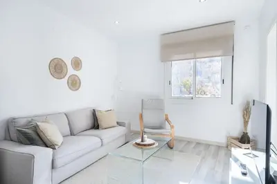 a white living room with a couch and a window at Apartment Next to Sagrada Familia, the Essence of Barcelona in Barcelona