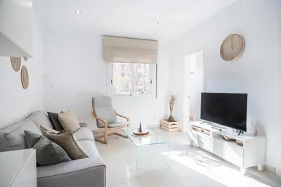 a white living room with a couch and a tv at Apartment Next to Sagrada Familia, the Essence of Barcelona in Barcelona