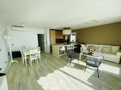 a living room with a couch and a table and chairs at La Marina2 SeaView with amazing terrace in Sitges