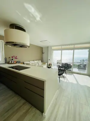 a kitchen with a sink and a living room at La Marina2 SeaView with amazing terrace in Sitges