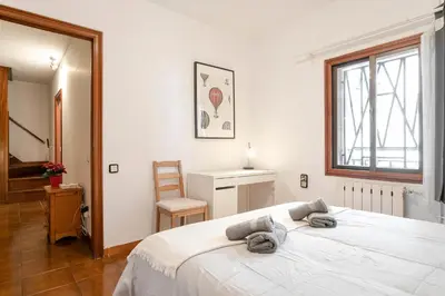 a bedroom with a large white bed and a chair at Barcelona Beach Home in Barcelona