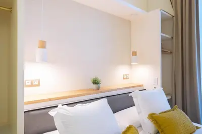 a hotel room with a bed with white pillows at Feelathome Casa Bertrand in Barcelona
