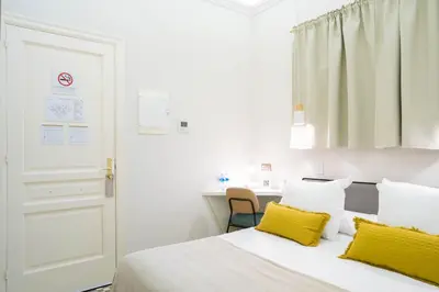a bedroom with a bed with yellow pillows and a desk at Feelathome Casa Bertrand in Barcelona