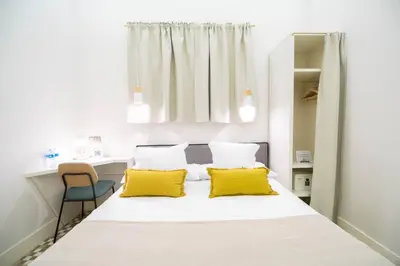 a bedroom with a large bed with yellow pillows at Feelathome Casa Bertrand in Barcelona