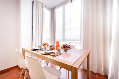 a dining room with a table and white chairs at Sweett - Eixample Central in Barcelona
