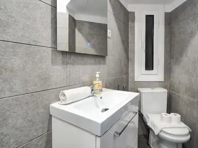 a bathroom with a white sink and a toilet at Pura Vida Apartment by Hello Homes Sitges in Sitges