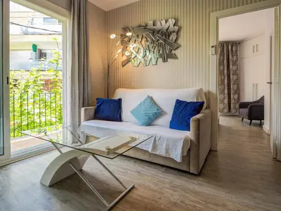 a living room with a couch and a glass table at Pura Vida Apartment by Hello Homes Sitges in Sitges