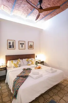 a bedroom with a large white bed with a ceiling at Tendency Apartments Miro 8 in Barcelona