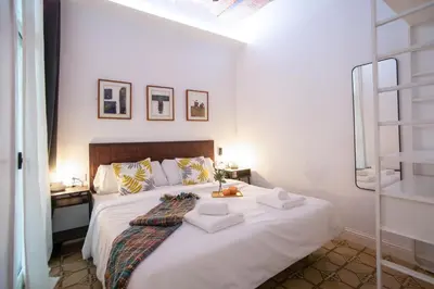 a bedroom with a large white bed with towels on it at Tendency Apartments Miro 8 in Barcelona