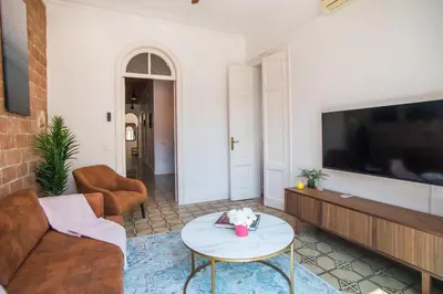 a living room with a couch and a tv at Tendency Apartments Miro 8 in Barcelona