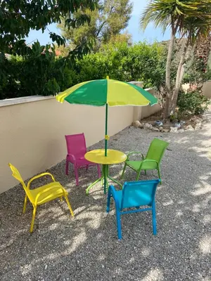 a table with four chairs and an umbrella at RACÓ DEL GARRAF Ca la Matilde house BBQ and POOL in Olivella