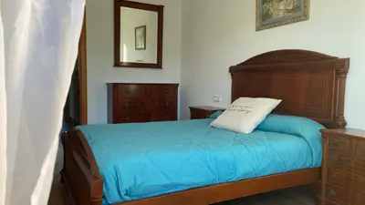 a bedroom with a wooden bed with a pillow on it at RACÓ DEL GARRAF Ca la Matilde house BBQ and POOL in Olivella