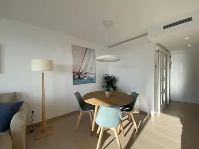 a living room with a table and chairs and a couch at Montaber Apartments - Sant Pol de Mar in San Pol de Mar