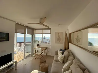 a living room with a couch and a television at Montaber Apartments - Sant Pol de Mar in San Pol de Mar