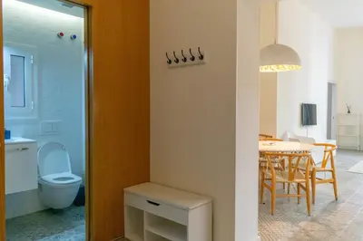 a bathroom with a toilet and a dining room with a table at 