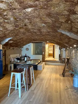 a kitchen and living room with a stone ceiling at Suíte Sant Sebastià con jacuzzi, sauna y jardín in Moià